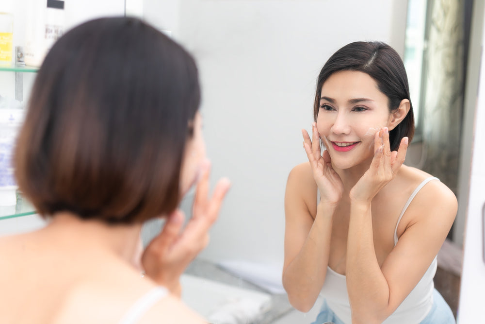 Woman looking at her face in the reflection.