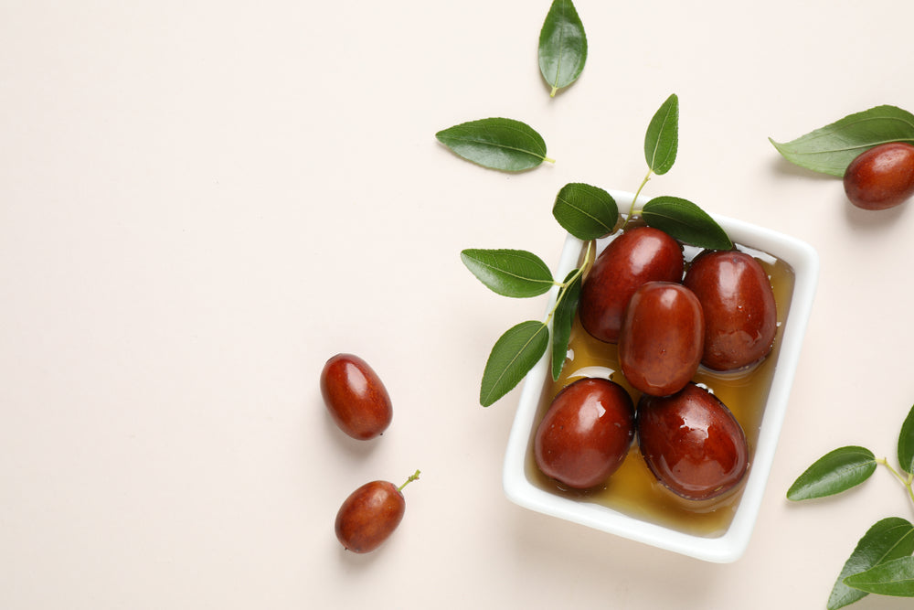 Jojoba seeds and oil in a sauce boat.