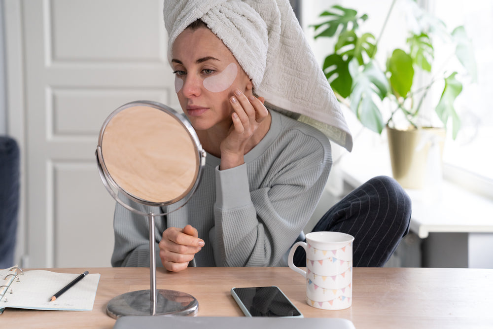 Woman looking under eye wrinkle treatments on her face in the mirror