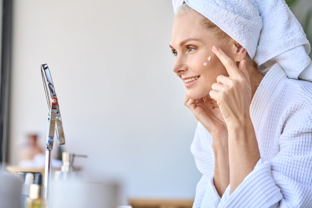 Woman applying skin hydrating cream to her face