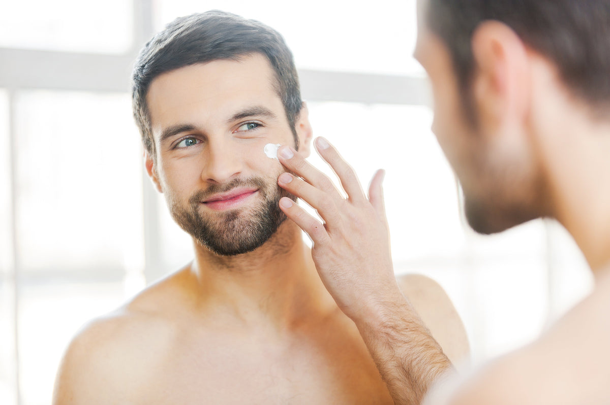 Man applying moisturizer to his cheek.