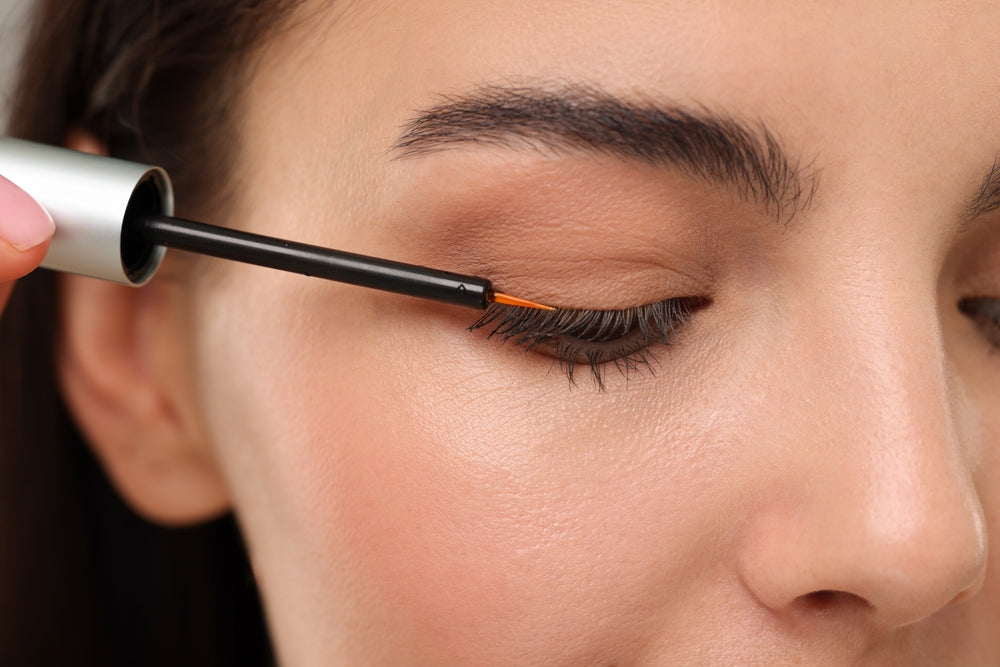 Woman applying eyelash serum 