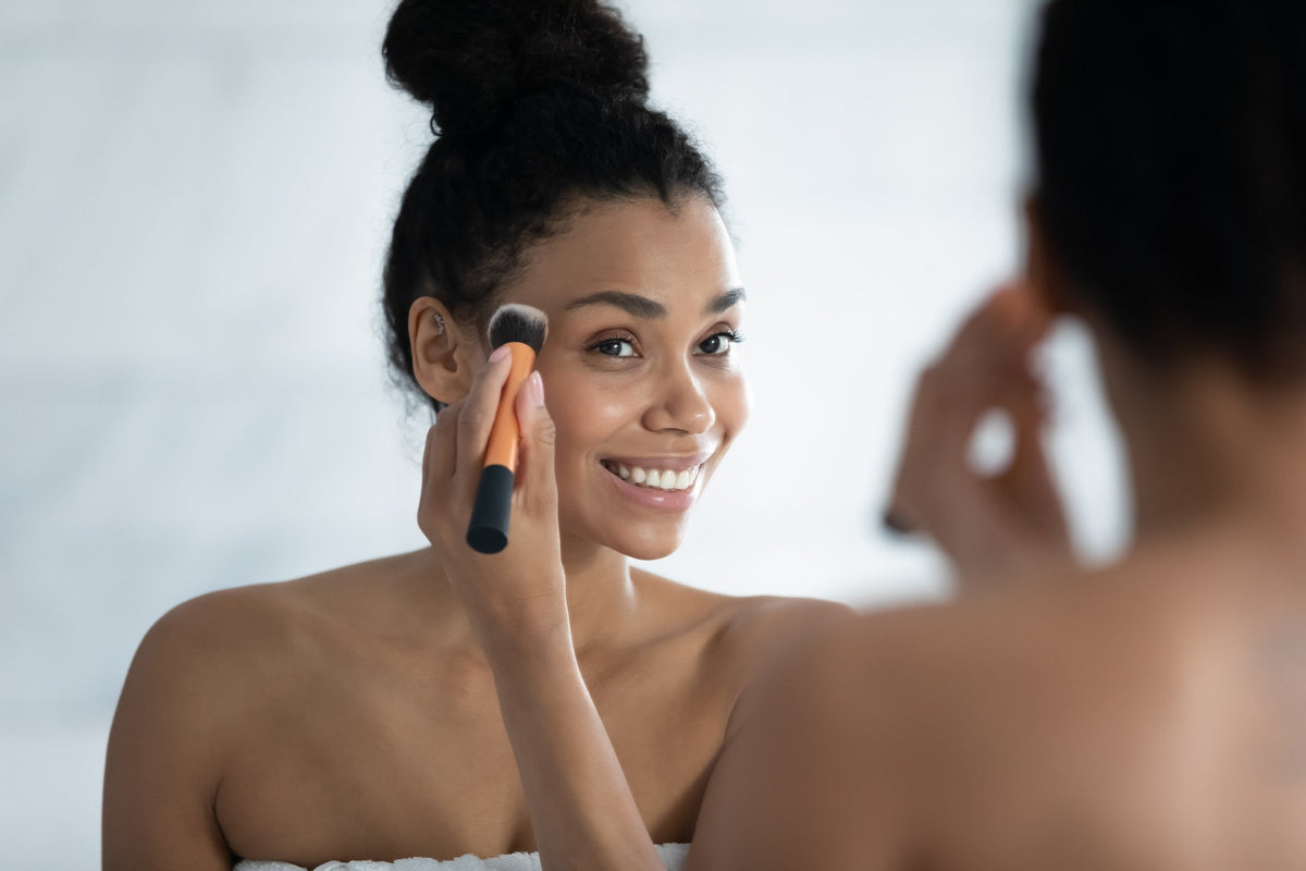Woman putting foundation on with a makeup brush