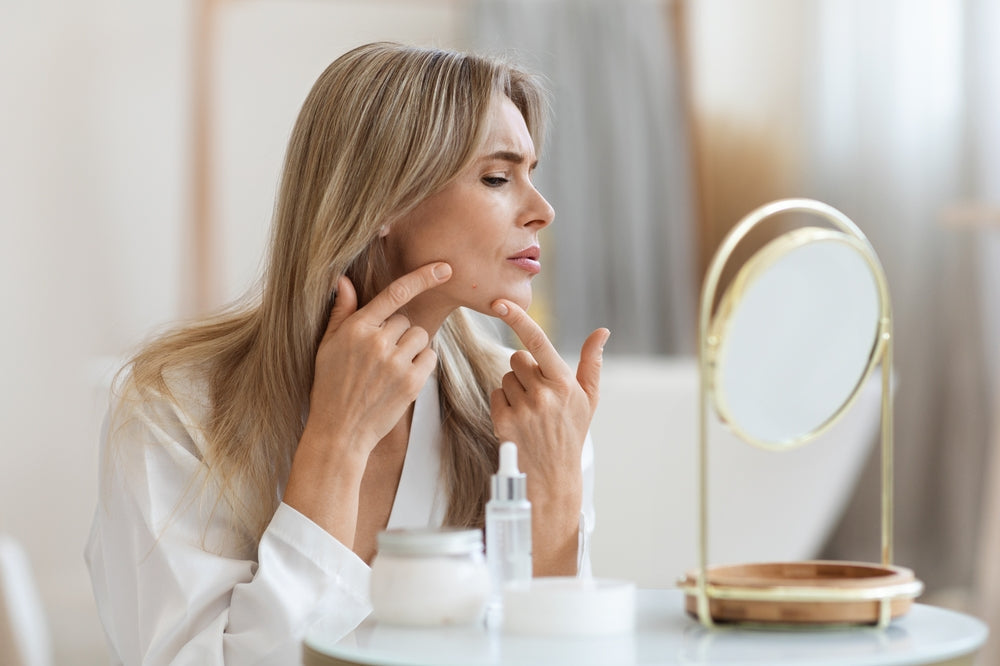 Woman looking at her skin in the mirror 