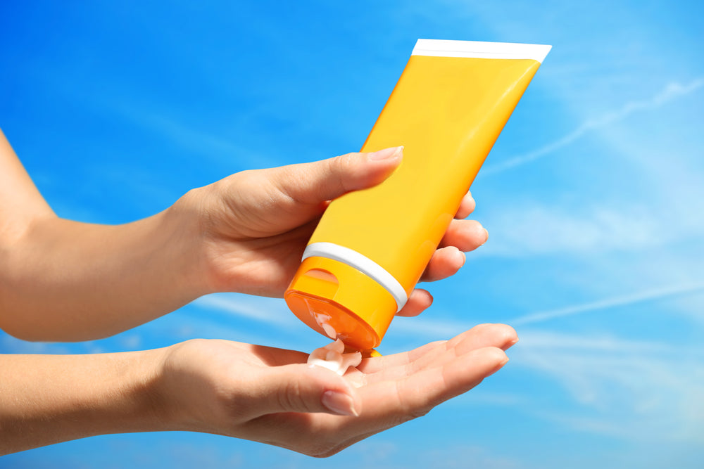 Someone squeezing sunscreen into their hands