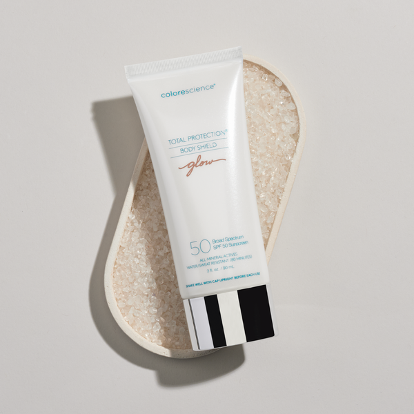 Tube of Colorescience Total Protection® Body Shield Glow SPF 50 on a textured stone surface