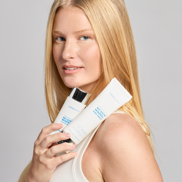 model holding bottle of no show mineral body shield and no show face sunscreen