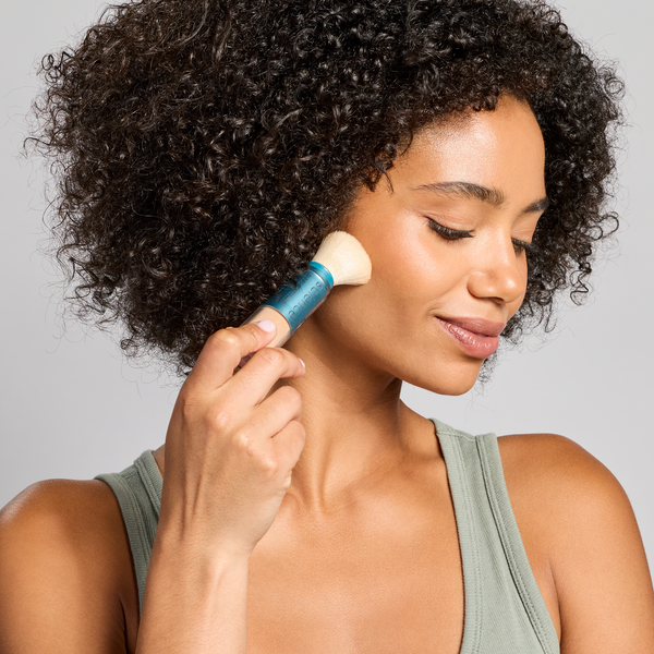 Woman applying brush SPF 50