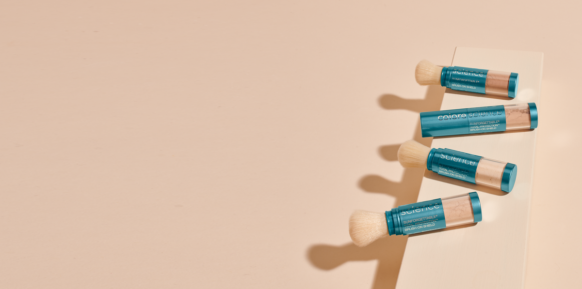 Four Colorescience Sunforgettable Total Protection Brush-On Shield SPF 50 brushes on a peach background